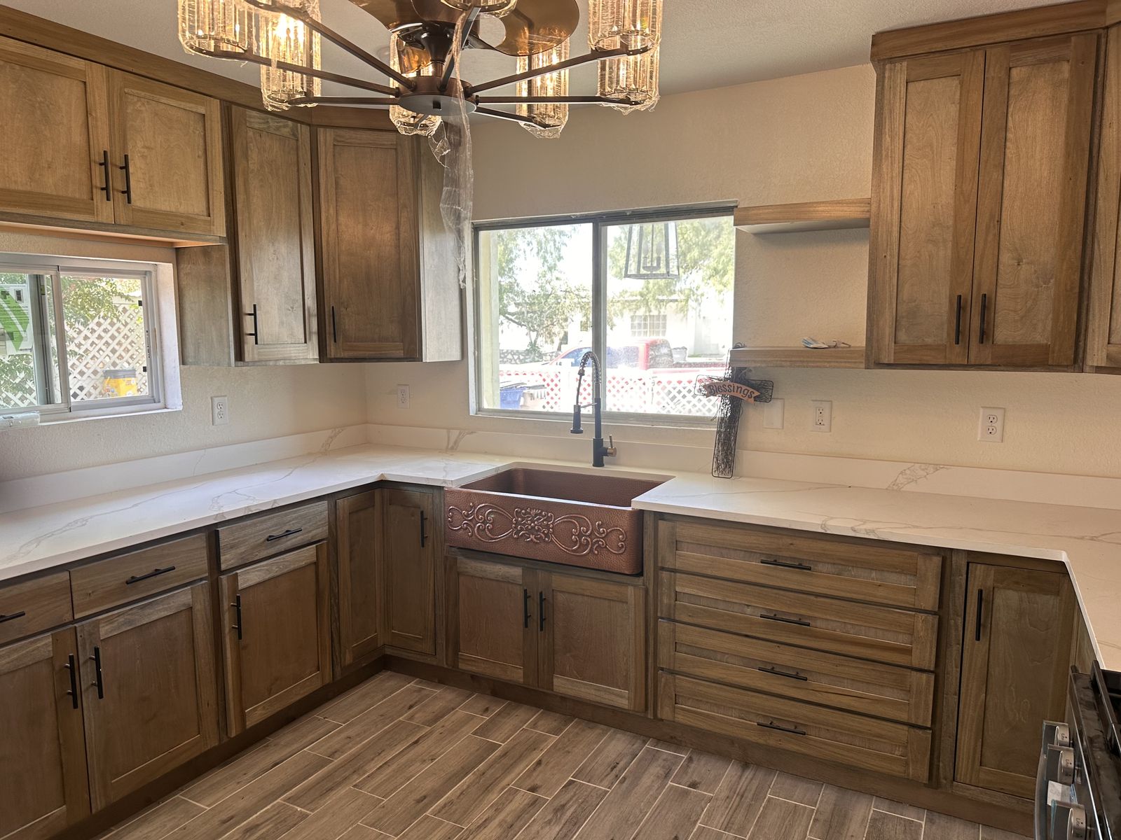 Stained wood shaker kitchen with a hammered copper farmhouse sink and white countertops